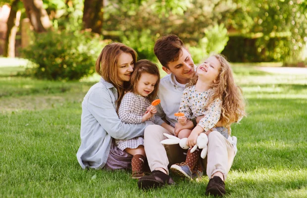 family sitting on green healthy grass