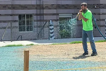 Technician hydroseeding lawn